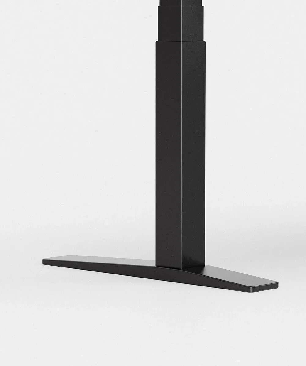 Studio close-up of a black E7 leg column meeting its centred T-foot on a pale grey background.