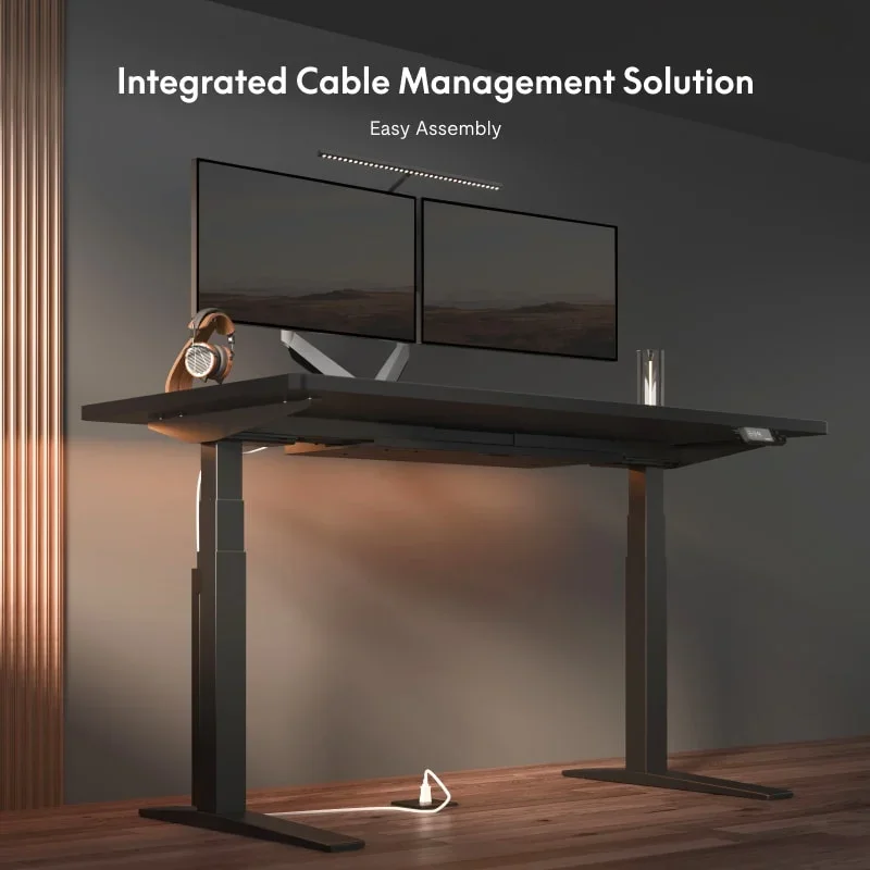 Black desk with dual monitors, a light bar and a headphone stand in a warm room with wood-slat walls, under a headline about integrated cable management and easy assembly.