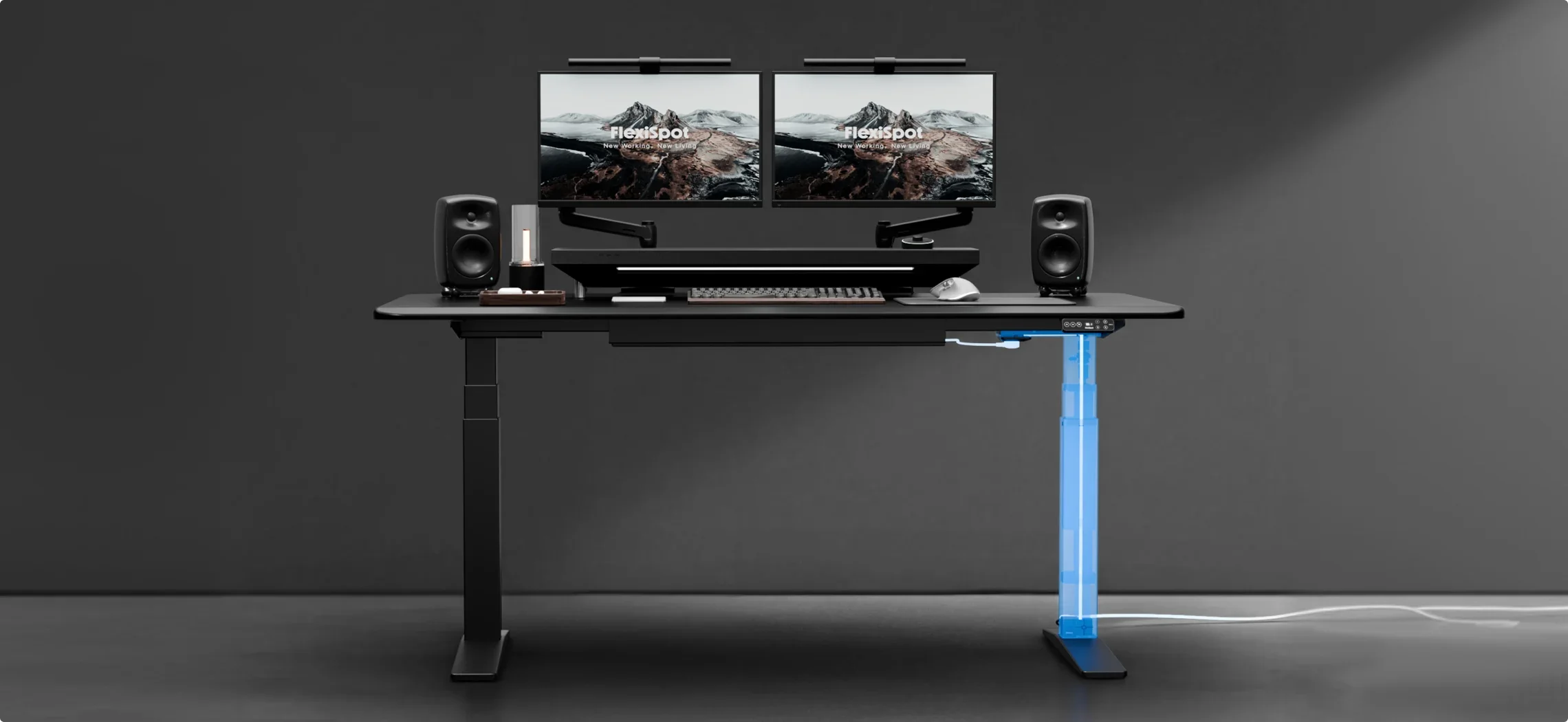 Wide render of the same black desk with dual monitors, now tidy with no visible cables and one leg lit blue to show the in-column routing.