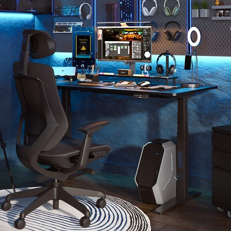 Black standing desk in a dark gaming room lit with blue neon, holding a monitor, headphones and pegboard accessories, with a black ergonomic chair, a PC tower on the floor and a round striped rug.