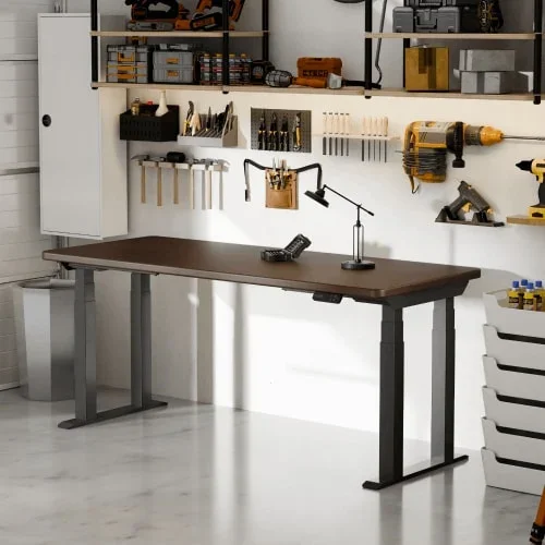 E7 Plus Max with a dark brown top and black frame in a garage workshop with tools on wall racks, a lamp and a white drawer tower.