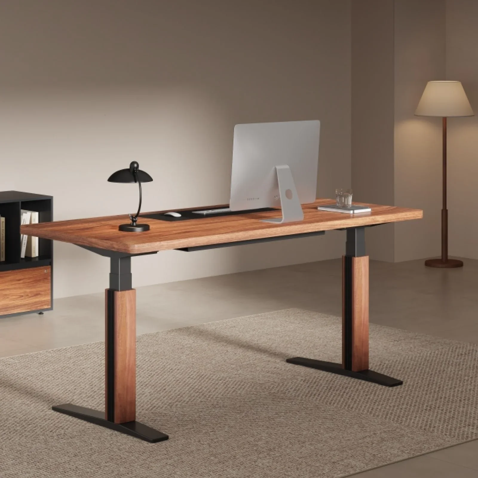 Lifestyle view of an E7 Pro with a walnut top and walnut leg covers in a warm, minimal study with an iMac, black desk lamp, floor lamp, shelving and rug.